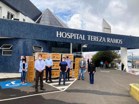 Sete pessoas posam em frente ao Hospital Tereza Ramos; são cinco homens e duas mulheres, todos usando máscaras.