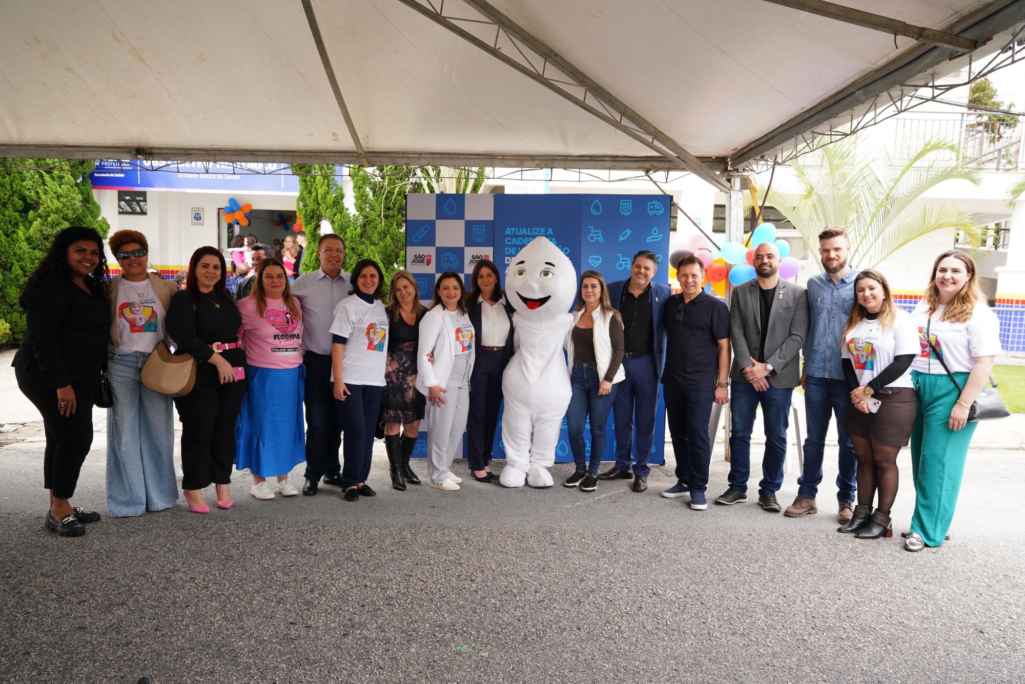 Equipes médicas com aventais e toucas cirúrgicas realizam procedimento em paciente em centro cirúrgico, com foco em cirurgia de mão ou braço.