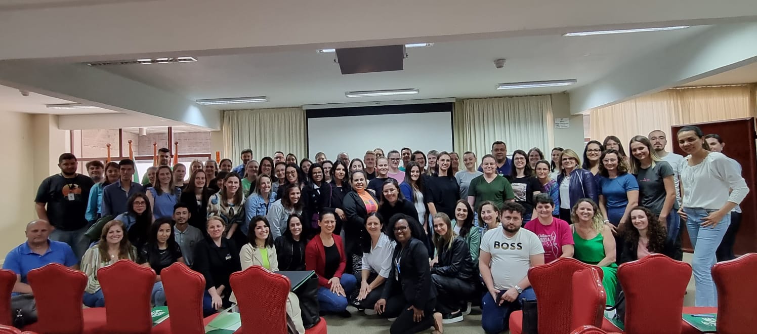 Equipe médica realizando cirurgia em ambiente hospitalar. Os profissionais usam toucas, máscaras e aventais estéreis, com iluminação concentrada na área da intervenção. A cena retrata concentração e trabalho em equipe em um centro cirúrgico.