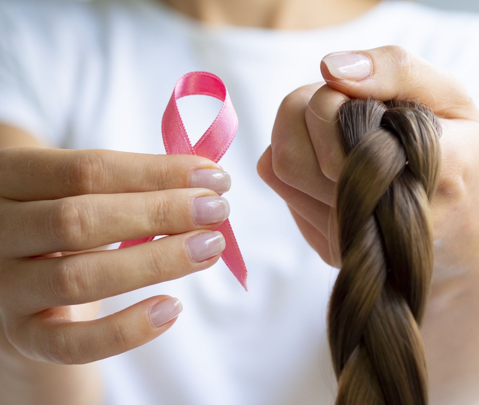 close up girl holding up braid Outubro Rosa