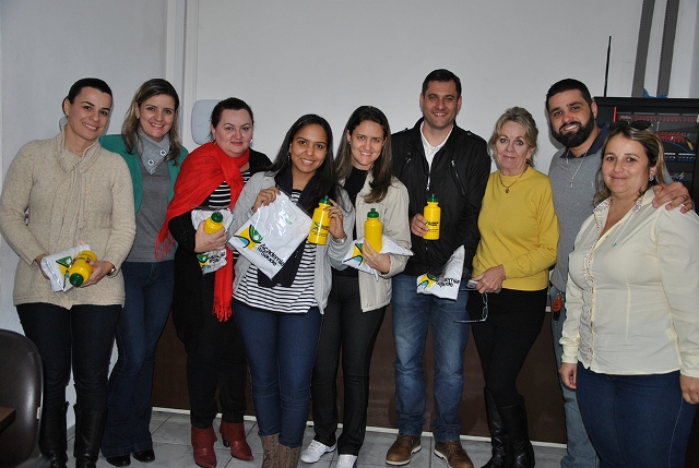 Grupo de nove pessoas, entre profissionais da saúde e técnicos do Ministério da Saúde e da UFSC, posam sorridentes para a foto em ambiente interno.