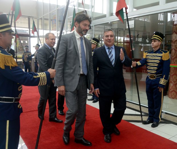 Governador Raimundo Colombo recebe o embaixador do Reino Unido, Vijay Rangarajan, no Centro Administrativo em Florianópolis. Eles caminham sobre o tapete vermelho, acompanhados por uma guarda de honra com uniformes cerimoniais.