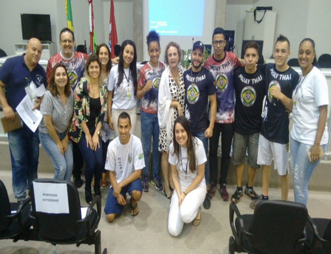 Grupo de participantes posando juntos em auditório durante o II Encontro pela Cultura da Paz, em São José. Entre eles, jovens com camisetas de Muay Thai, profissionais da saúde e representantes da Escola de Formação em Saúde (EFOS) da Secretaria de Estado da Saúde de Santa Catarina.