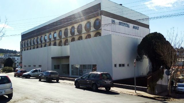Fachada do Hospital Maicé, localizado em Caçador, Santa Catarina, em um dia ensolarado. O prédio tem três andares, com janelas arredondadas no último pavimento, e aparência moderna após reformas.
