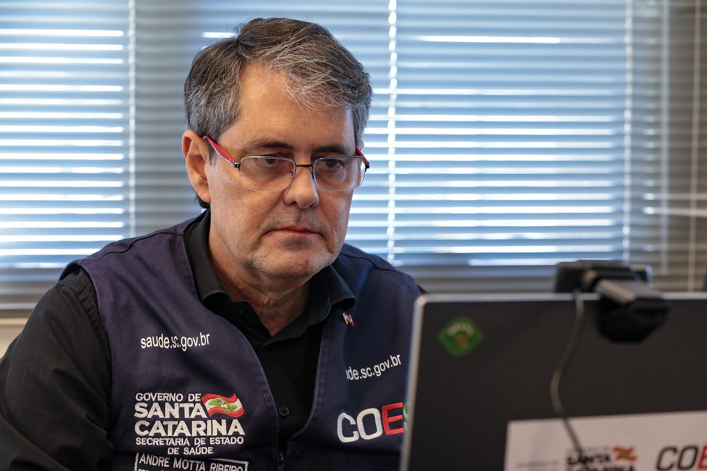 Secretário de Estado da Saúde, André Motta Ribeiro, observando atentamente um monitor.