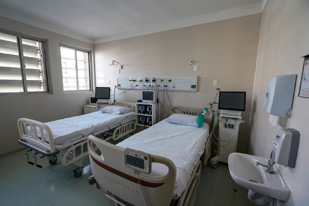Leito de UTI moderno e desocupado, com equipamentos hospitalares.