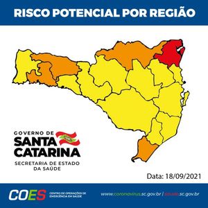 Mapa do estado de Santa Catarina dividido por regiões e colorido para indicar risco potencial por região. A maioria das regiões está em amarelo (risco moderado), algumas em laranja (risco alto) e uma região no nordeste em vermelho (risco gravíssimo). No canto inferior esquerdo, há o logotipo do Governo de Santa Catarina e da Secretaria de Estado da Saúde. A data indicada é 18/09/2021.