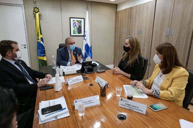 Governadora Daniela Reinehr e três autoridades em reunião de trabalho com o Ministro da Saúde, discutindo demandas de Santa Catarina em mesa com documentos oficiais.