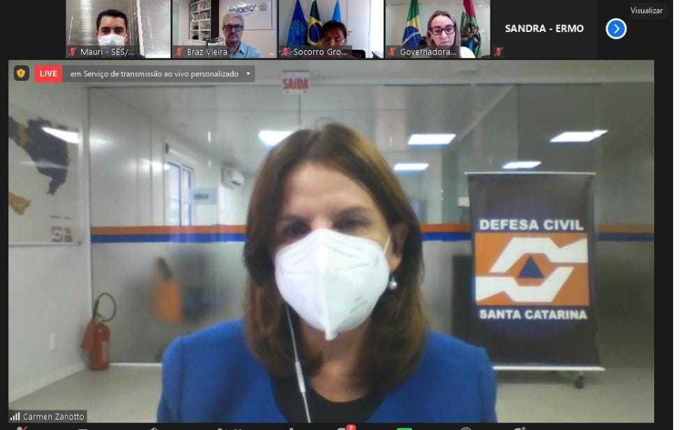 A secretária da Saúde de Santa Catarina participa de uma videoconferência com a governadora e outras autoridades, exibida em uma tela dividida.