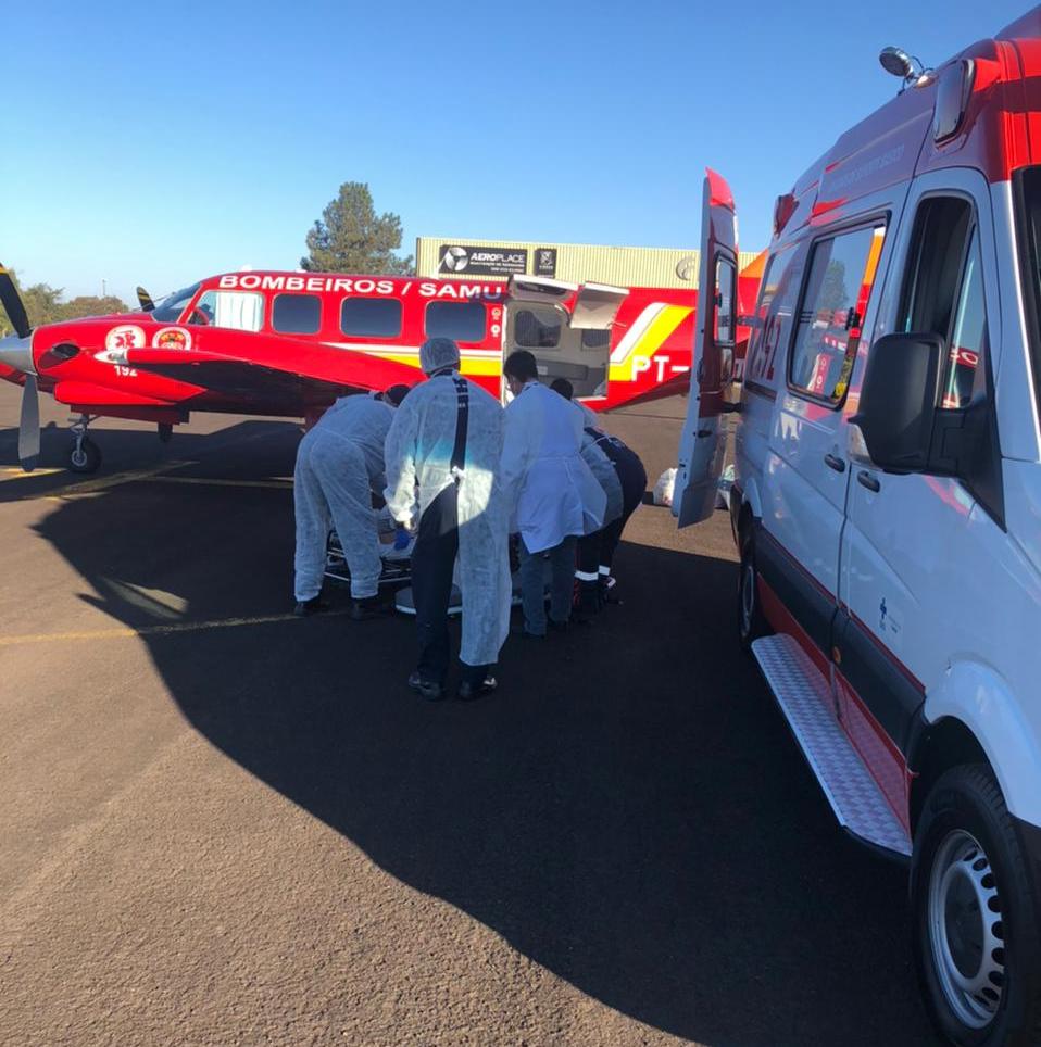 Equipe médica na frente de avião vermelho dos bombeiros/samu