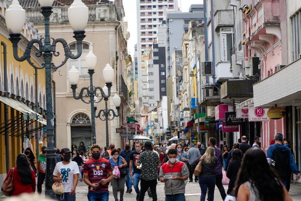 Multidão caminhando no centro de Florianópolis com maioria usando máscaras, em dia de novas regras de enfrentamento à pandemia em Santa Catarina.
