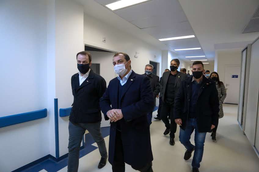 Governador andando pelo hospital com muitas pessoas andando atrás 