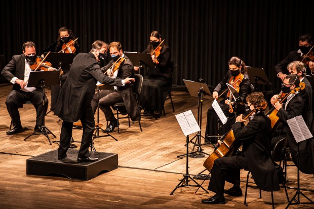 Orquestra tocando, todos de máscara 