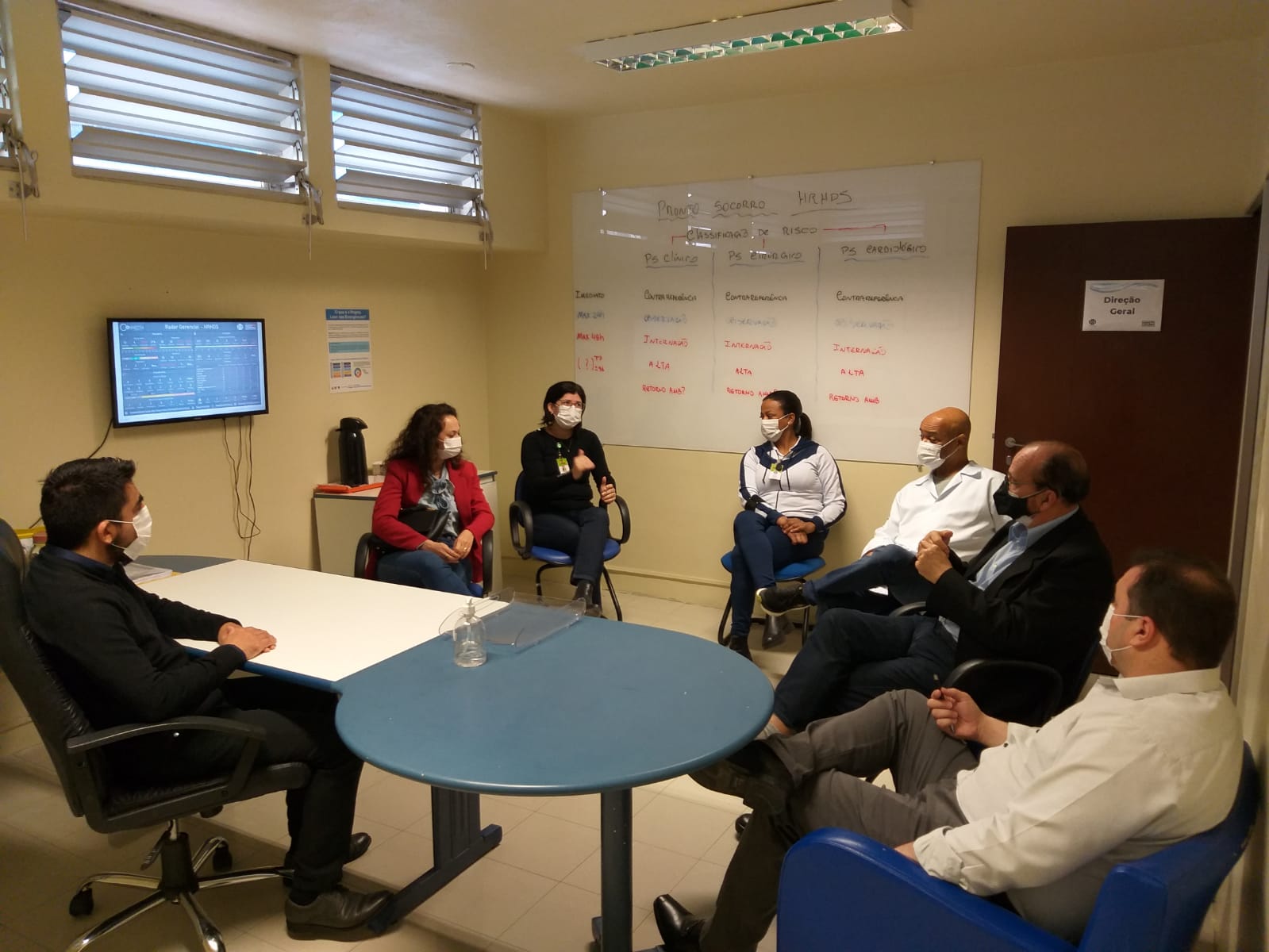 Pessoas reunidos em roda no interior de uma sala.