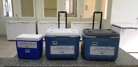 Três caixas térmicas azuis dispostas sobre uma mesa, organizadas da menor para a maior da esquerda para a direita.