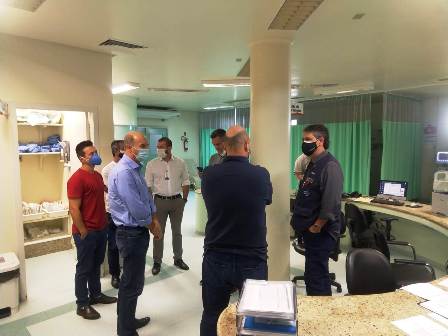 Grupo de pessoas reunidas na área de recepção de um hospital, aguardando atendimento.
