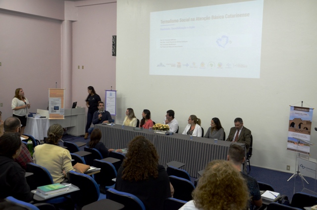 Palestrantes sentados à mesa em auditório durante o lançamento do livro 